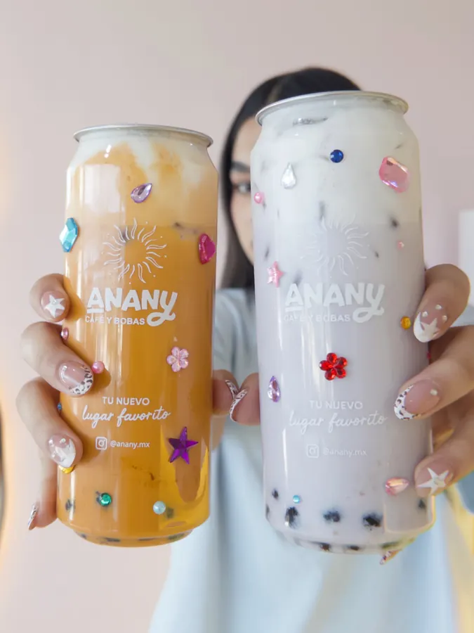 Dos latitas con gemas sostenidas hacia la cámara